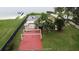 Aerial view of the property showing its backyard with patio, lush lawn, and lakefront access with dock at 5529 Hansel Ave, Orlando, FL 32809