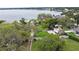 Waterfront property showcasing a lush lawn, mature trees, and a private sandy beach, with lake views at 5529 Hansel Ave, Orlando, FL 32809