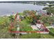 Waterfront property showcasing a lush lawn, mature trees, and a private sandy beach, outlined in red at 5529 Hansel Ave, Orlando, FL 32809