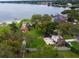 Waterfront property showcasing a lush lawn, mature trees, and a private sandy beach, with lake views at 5529 Hansel Ave, Orlando, FL 32809