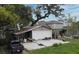 Backyard view featuring a concrete patio, mature trees, and a detached garage, ready for customization at 5529 Hansel Ave, Orlando, FL 32809