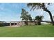The home features a backyard with patio, chairs, lush lawn, and lakefront access, perfect for outdoor living at 5529 Hansel Ave, Orlando, FL 32809