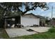 Backyard view featuring a concrete patio, mature trees, and a detached garage, ready for customization at 5529 Hansel Ave, Orlando, FL 32809