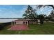 View of the backyard with patio, chairs, lush lawn, and lakefront access, perfect for outdoor living at 5529 Hansel Ave, Orlando, FL 32809
