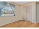 Comfortable bedroom featuring hardwood floors, a window, and a closet at 5812 Viking Rd, Orlando, FL 32808