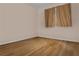 Cozy bedroom features hardwood floors and a window with simple curtains at 5812 Viking Rd, Orlando, FL 32808