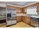 Functional kitchen with stainless steel appliances, wooden cabinetry, and a double basin sink and tile backsplash at 5812 Viking Rd, Orlando, FL 32808