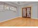 Cozy living room with hardwood floors, natural light from the window, and decorative wooden door to another room at 5812 Viking Rd, Orlando, FL 32808