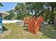 Backyard with a deck, an above-ground pool, green grass, and trees in the background at 6663 Nw 60Th St, Ocala, FL 34482