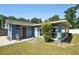 View of home's backyard with a chair, two exterior doors, some grass, and a tree at 6663 Nw 60Th St, Ocala, FL 34482
