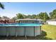 Backyard featuring a large above-ground pool, wooden deck, and view of the home's exterior at 6663 Nw 60Th St, Ocala, FL 34482