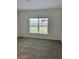 Bright bedroom features neutral carpet, a large window for natural light, and freshly painted white walls at 6841 Wilson Hammock Ave, Groveland, FL 34736