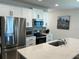 Modern kitchen featuring stainless steel appliances, white cabinets, and quartz countertops at 6841 Wilson Hammock Ave, Groveland, FL 34736