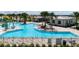 Community swimming pool is surrounded by palm trees, comfortable lounge chairs, and a covered clubhouse at 6841 Wilson Hammock Ave, Groveland, FL 34736