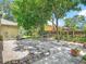 Paved backyard patio with mature trees and garden area, providing a private and serene outdoor space at 700 E Mattie St, Sanford, FL 32773