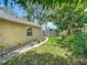 Well-maintained backyard with lush green grass, a stone pathway, and mature trees at 700 E Mattie St, Sanford, FL 32773