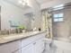 A bright bathroom featuring double vanity and a tub-shower combo with stylish, modern tile surround at 700 E Mattie St, Sanford, FL 32773