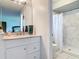 Bathroom featuring a granite vanity and a walk-in shower with elegant marble-look tile surround at 700 E Mattie St, Sanford, FL 32773