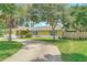 A well-maintained home featuring a long driveway, lush lawn, and mature trees providing shade and privacy at 700 E Mattie St, Sanford, FL 32773