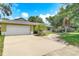 Charming single-story home featuring an attached two-car garage and a lush front yard with mature trees at 700 E Mattie St, Sanford, FL 32773