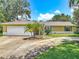 Charming single-story home with a two-car garage, complimented by a well-manicured lawn and mature palm trees at 700 E Mattie St, Sanford, FL 32773