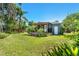 Well-maintained backyard featuring a covered patio, lush lawn, and mature trees offering shade at 725 S Hampton Ave, Orlando, FL 32803