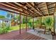 A view of a backyard with a covered deck, seating, green plants, and a blue house at 725 S Hampton Ave, Orlando, FL 32803