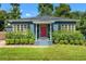 Charming single-story home with a red front door, lush landscaping, and a well-manicured lawn at 725 S Hampton Ave, Orlando, FL 32803