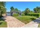 Attractive single-story home with lush landscaping, a brick driveway, and a beautifully manicured lawn at 725 S Hampton Ave, Orlando, FL 32803