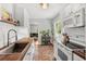 Bright kitchen with brick floors, white cabinets, wood countertops, and stainless steel sink at 725 S Hampton Ave, Orlando, FL 32803
