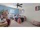 Cozy bedroom featuring blue accent wall, ceiling fan, and natural light at 750 Maple Leaf Loop, Winter Springs, FL 32708
