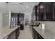 The kitchen features granite counters, dark cabinetry and modern stainless appliances at 750 Maple Leaf Loop, Winter Springs, FL 32708