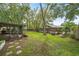 Spacious backyard featuring lush lawn, mature trees, screened lanai and patio area at 7806 Compass Dr, Orlando, FL 32810