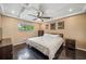 Comfortable bedroom with dark hardwood floors, ceiling fan, and natural light at 7806 Compass Dr, Orlando, FL 32810