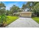 Charming single-story home boasting a well-manicured lawn, mature trees, and a long driveway leading to a two-car garage at 7806 Compass Dr, Orlando, FL 32810