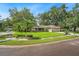 Corner lot home with mature trees, landscaping, green grass, and two car garage at 7806 Compass Dr, Orlando, FL 32810
