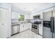 Updated kitchen featuring stainless steel appliances, white cabinets, granite counters and tile floors at 7806 Compass Dr, Orlando, FL 32810