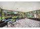 Covered lanai with stone flooring, screen enclosure, and outdoor seating area at 7806 Compass Dr, Orlando, FL 32810