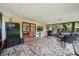 Relaxing lanai with stone flooring, grill, tv, screen enclosure, and outdoor seating at 7806 Compass Dr, Orlando, FL 32810