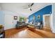 Bright living room with wood floors, gray leather sofas, blue accent wall, and natural light at 7806 Compass Dr, Orlando, FL 32810