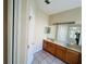 Bathroom featuring a double sink vanity with wooden cabinets and a large mirror at 830 Moonlit Ln, Casselberry, FL 32707