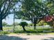 Green community area with a fountain, white fencing, and mature trees under a sunny sky at 830 Moonlit Ln, Casselberry, FL 32707
