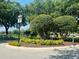Well-maintained community entrance featuring manicured landscaping and white fencing at 830 Moonlit Ln, Casselberry, FL 32707
