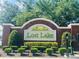 Entrance to the Lost Lake neighborhood featuring lush green landscaping at 830 Moonlit Ln, Casselberry, FL 32707