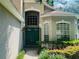 Inviting front entrance features a beautiful, double door, arched window, and manicured landscaping at 830 Moonlit Ln, Casselberry, FL 32707
