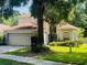 Charming two-story home boasts mature trees, manicured lawn, and attached two-car garage at 830 Moonlit Ln, Casselberry, FL 32707