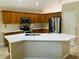 Bright kitchen featuring stainless steel appliances, wooden cabinets, and a center island with a double sink at 830 Moonlit Ln, Casselberry, FL 32707