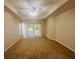 Spacious main bedroom featuring carpet floors, a ceiling fan, and glass sliding doors to the lanai at 830 Moonlit Ln, Casselberry, FL 32707