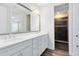 Bathroom with a double sink vanity, large mirror, and a separate shower with a glass door at 8480 Adalina Pl, Orlando, FL 32827