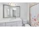 Bathroom features a white vanity with a large mirror, a toilet, and a shower with a floral curtain at 8480 Adalina Pl, Orlando, FL 32827
